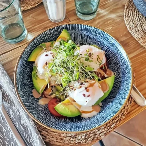 Bowl de brunch com ovo pochê e abacate, saudável e energizante.