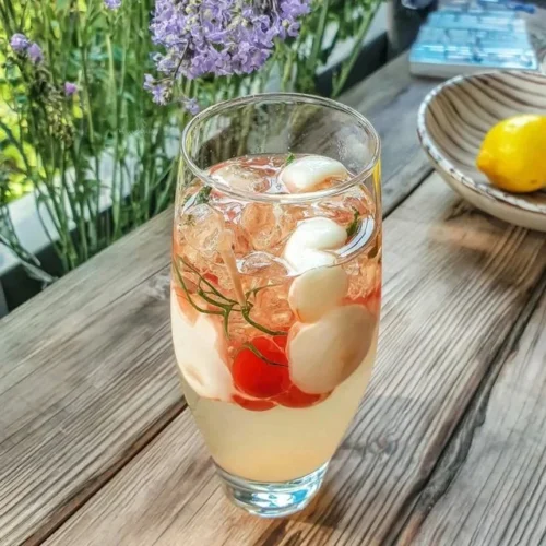Copo de Limonada Rosa Refrescante com frutas e gelo.