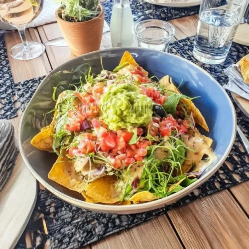 Deliciosos nachos cobertos com guacamole cremoso e salsa fresca.